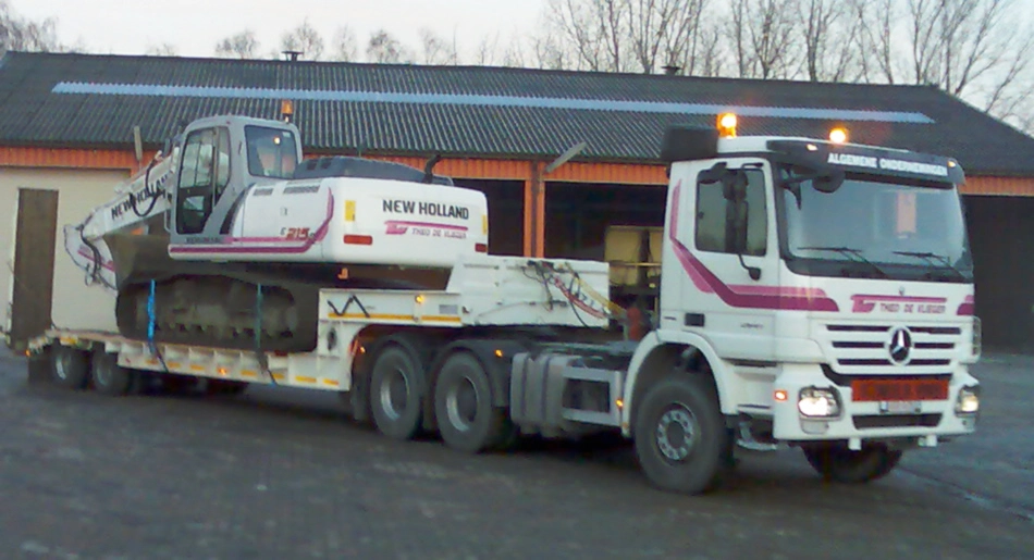 Camion van TDV Wegenbouw dat een kraan van TDV Wegenbouw wegrijdt